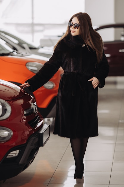 Una joven empresaria está probando autos en una tienda de autos