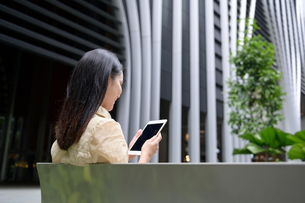 Una joven empresaria está trabajando en el centro de la ciudad moderna de Singapur