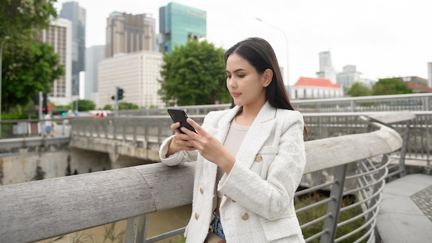 Una joven empresaria está trabajando en el centro de la ciudad moderna de Singapur