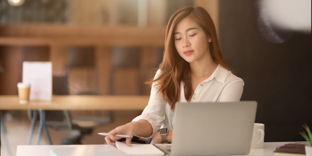 Joven empresaria exitosa trabajando en su proyecto en la oficina moderna