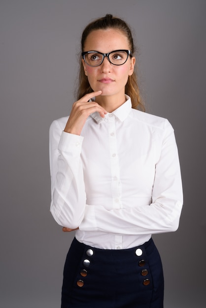 Joven empresaria hermosa contra el fondo gris