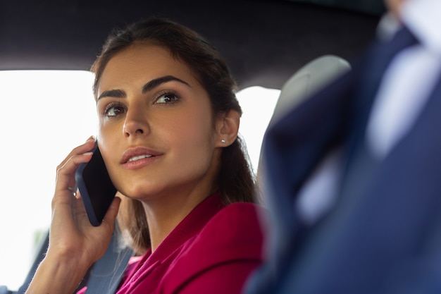 Joven empresaria. Hermosa joven empresaria llamando a secretaria sentada cerca de marido