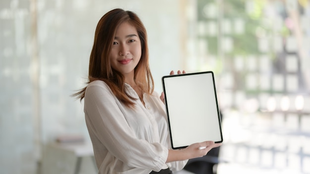 joven empresaria hermosa mostrando tableta de pantalla en blanco