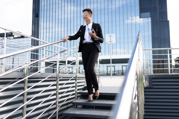 Joven empresaria hermosa posando contra el edificio moderno