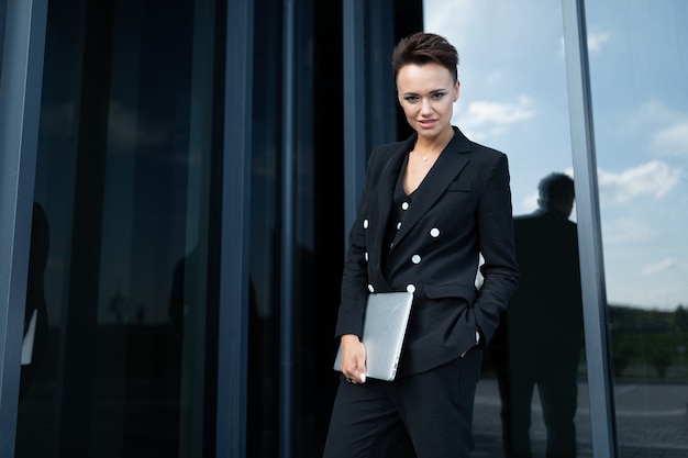 Foto joven empresaria hermosa posando contra el edificio moderno