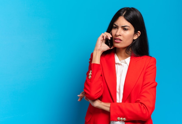 Joven empresaria hispana usando su teléfono