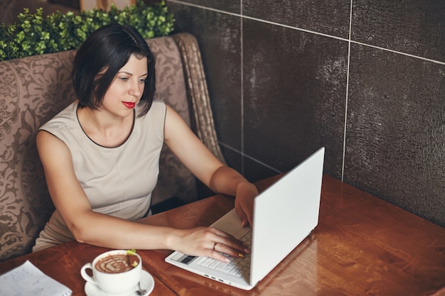 Joven empresaria con laptop y notebook