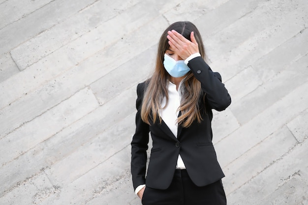 Joven empresaria con mascarilla y comprobando su temperatura