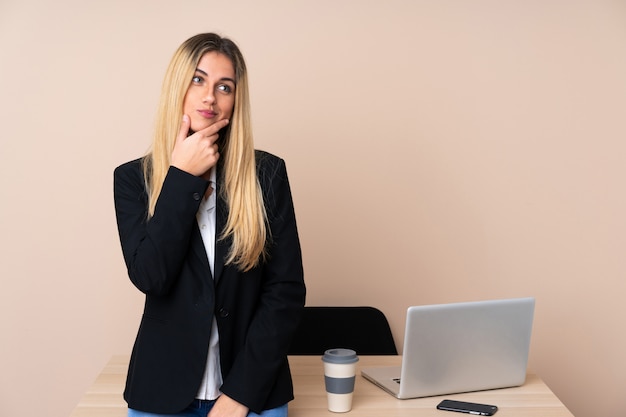 Joven empresaria en una oficina pensando en una idea