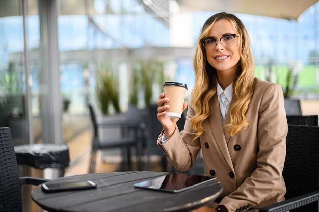 Joven empresaria en una pausa para el café, sonriendo a la cámara