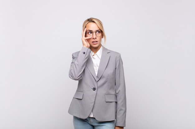 Joven empresaria que se siente aburrida, frustrada y con sueño después de una tarea tediosa, aburrida y tediosa, sosteniendo la cara con la mano