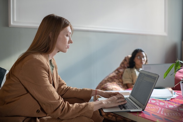 Foto joven empresaria de redes delante de la computadora portátil en la oficina