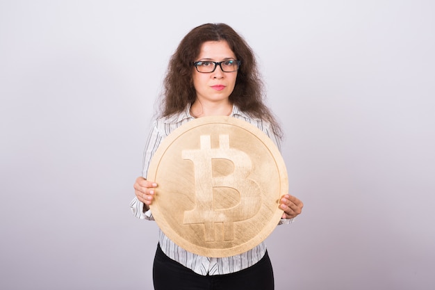 Joven empresaria sosteniendo un bitcoin dorado