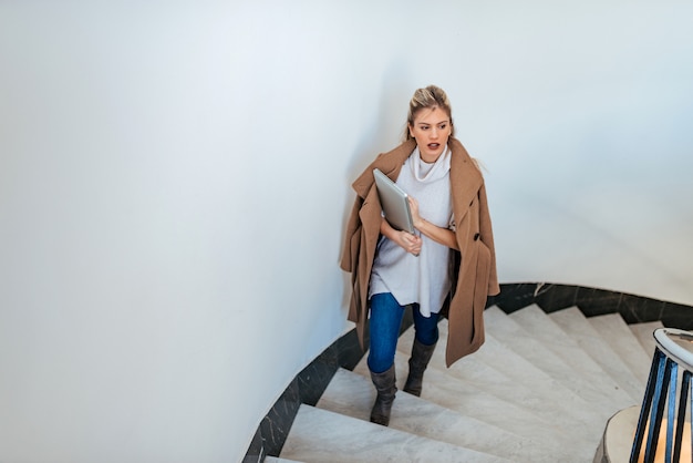 Joven empresaria subiendo las escaleras.