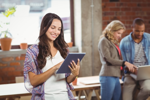 Joven empresaria con tableta digital en la oficina