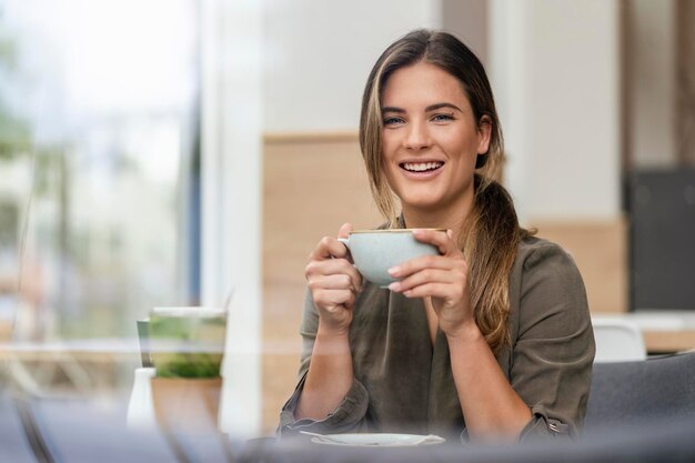 Joven empresaria con taza de café en un café