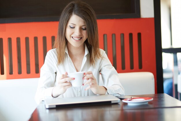 Joven empresaria trabajando en café