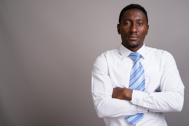 Joven empresario africano guapo contra el fondo gris