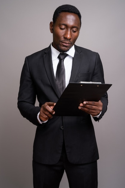 Joven empresario africano guapo contra el fondo gris