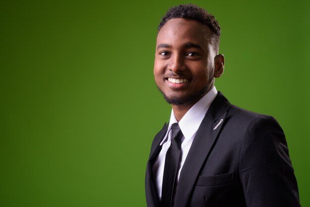 Joven empresario africano guapo contra fondo verde