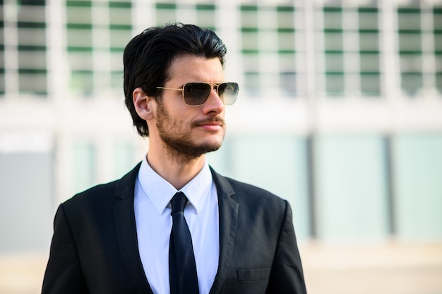 Joven empresario al aire libre con gafas de sol