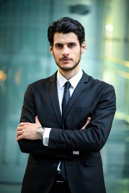 Joven empresario al aire libre sonriendo con confianza