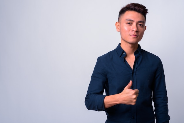 joven empresario asiático contra el espacio en blanco