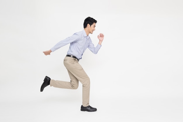 Joven empresario asiático corriendo hacia adelante aislado sobre fondo blanco.