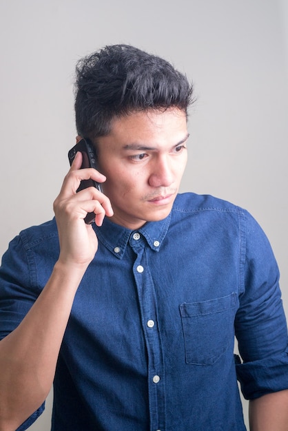 Joven empresario asiático guapo hablando por teléfono