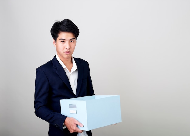 Joven empresario asiático sosteniendo una caja