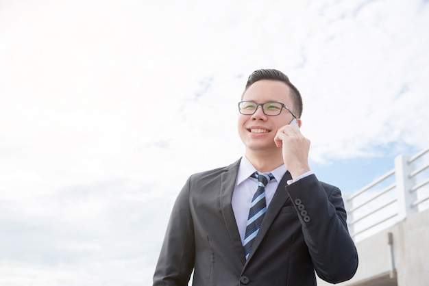 Joven empresario asiático vistiendo traje negro sonriendo