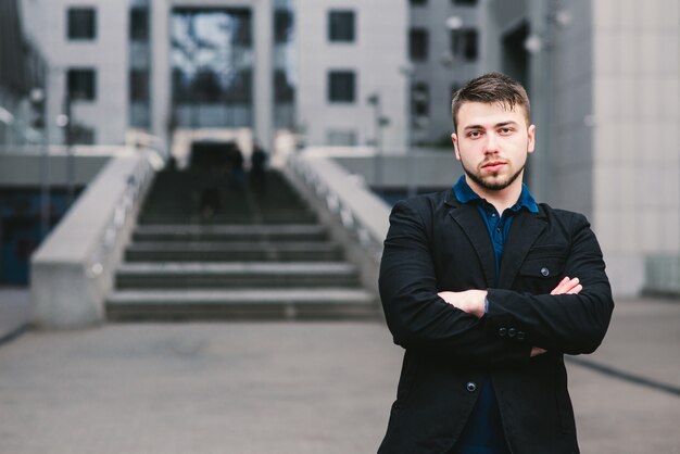 Joven empresario con barba cerca de un edificio moderno