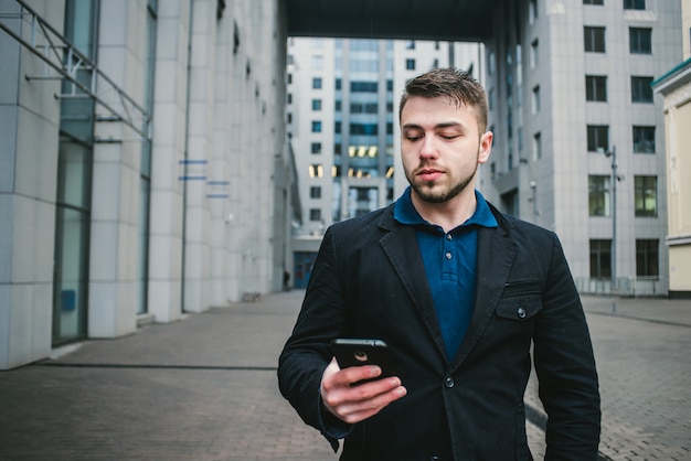 Joven empresario con barba usando un teléfono