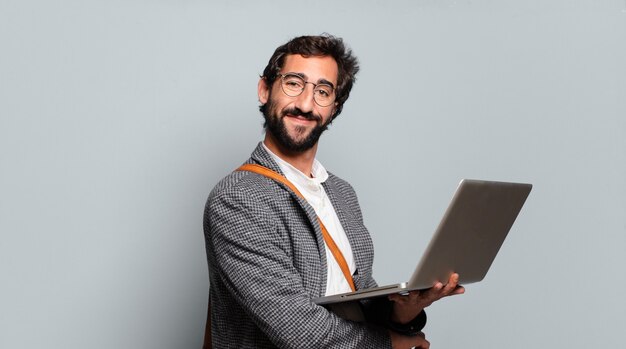 Joven empresario barbudo y loco con un portátil