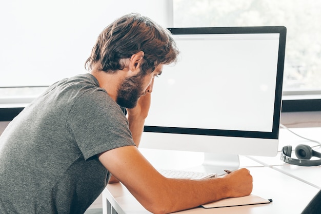 Joven empresario barbudo que trabaja en la oficina moderna