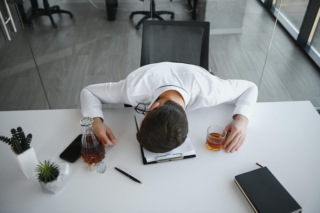 Joven empresario bebiendo del estrés