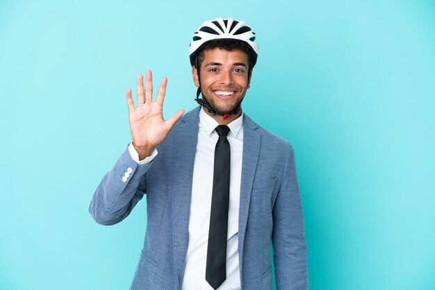 Joven empresario brasileño con casco de bicicleta aislado de fondo azul contando cinco con los dedos