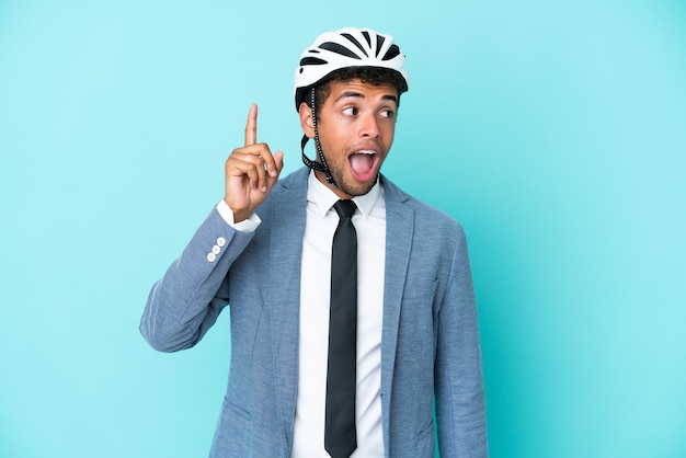 Joven empresario brasileño con casco de bicicleta aislado sobre fondo azul con la intención de darse cuenta de la solución mientras levanta un dedo hacia arriba