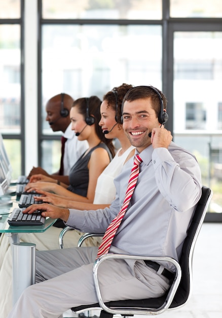 Joven empresario en un call center sonriendo a la cámara