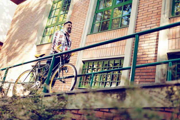 Joven empresario casual yendo a trabajar en bicicleta.