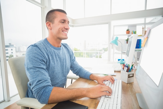 Joven empresario creativo escribiendo en la computadora