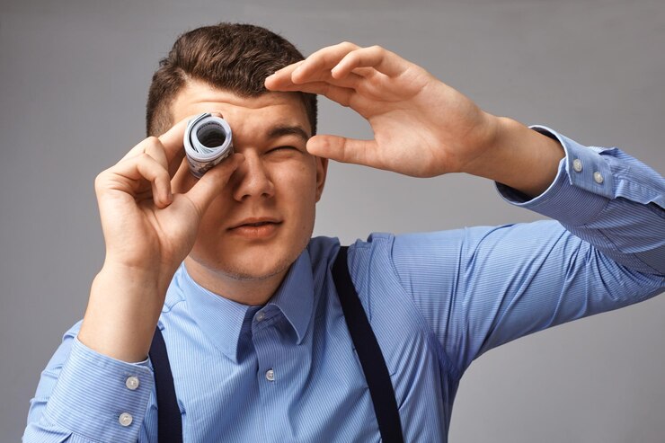 Foto un joven empresario elegante mirando a través de un tubo de billetes de dólar