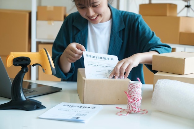 Joven empresario empacando productos de pedidos en línea para envío