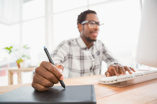 Joven empresario escribiendo en la tableta gráfica