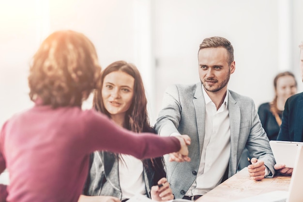 Foto joven empresario estrechando la mano de su socio comercial