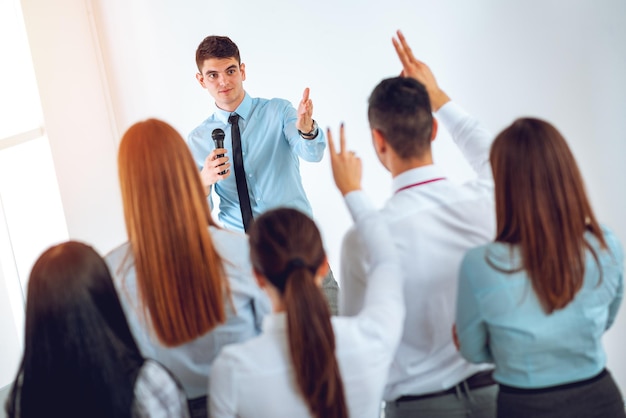 Foto joven empresario explicando a sus colegas el plan de trabajo. el equipo está escuchando.