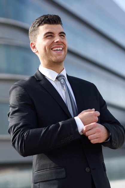 Joven empresario feliz mirando hacia otro lado