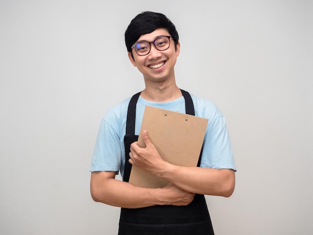 Joven empresario feliz sonrisa vistiendo delantal abrazo tablero de documentos