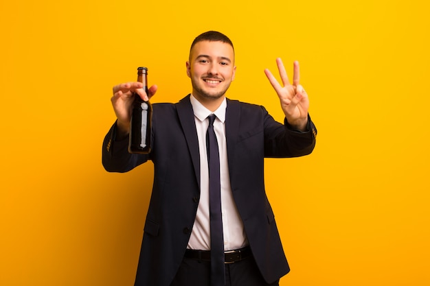 Joven empresario guapo contra el fondo plano con una cerveza