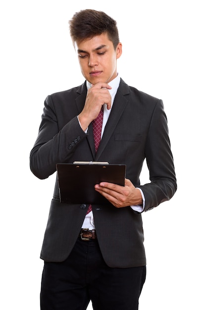 Joven empresario guapo leyendo en el portapapeles mientras piensa